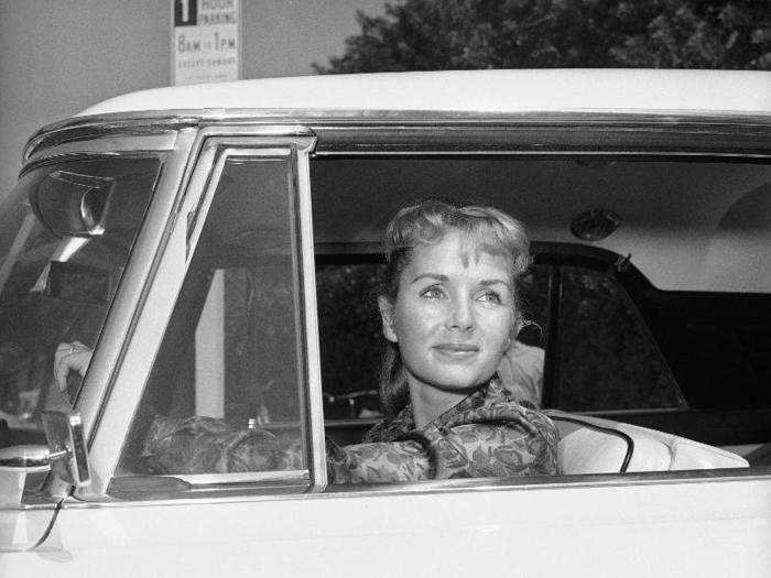 Reynolds, faced with the break-up of her marriage to Fisher, keeps her emotions concealed beneath a grin as she chats briefly with newsmen outside her home in Los Angeles, Sept. 11, 1958. She told them that Fisher had moved out, that she didn