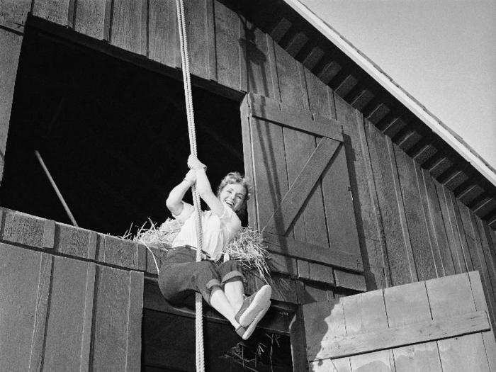 Reynolds swings from a rope outside the haymow of a barn on the MGM lot in Hollywood, Sept. 30, 1958. She was filming her first picture since she and singer Eddie Fisher parted ways.