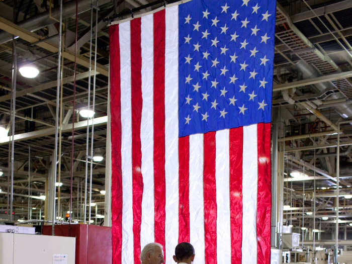 Obama and Biden walk arm in arm before speaking at the Chrysler Transmission Plant.