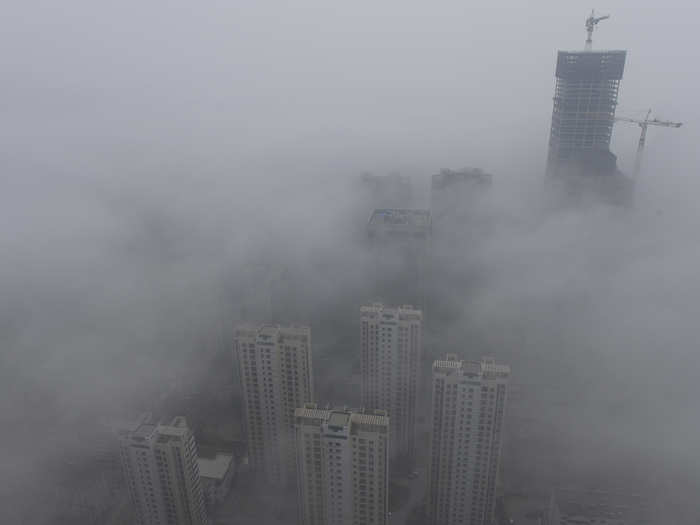 High-rise buildings are shrouded in heavy haze all the way up to the top of the Qingdao development zone.