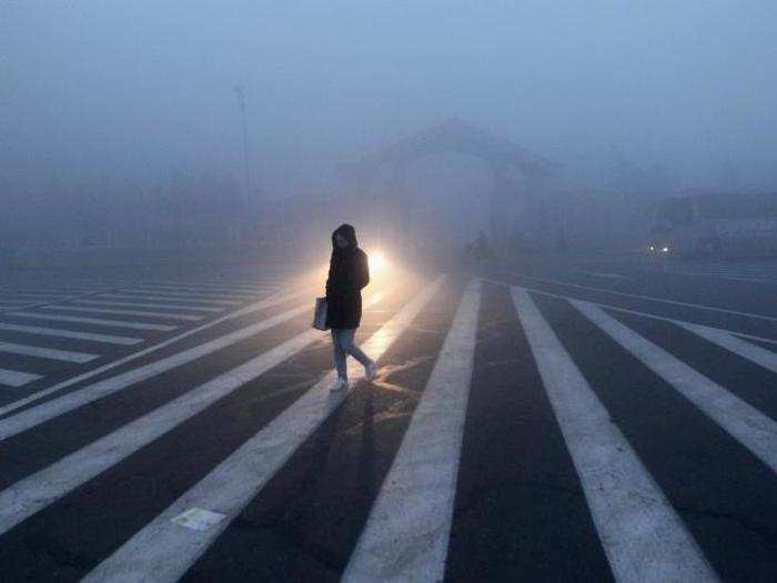 A woman makes her way through traffic in Changchun.