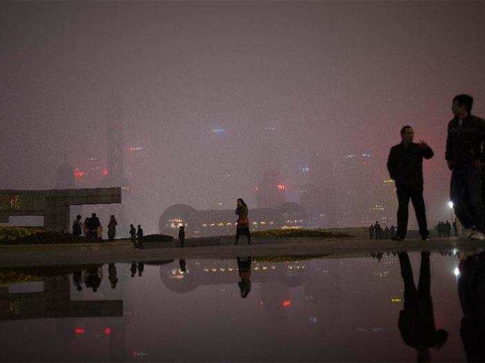 People walk on the Bund, a waterfront area near the financial district of Pudong in downtown Shanghai.