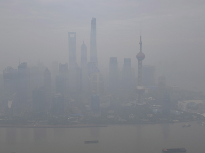 Boats pass along the Huangpu River next to the financial area of the Pudong New District amid heavy smog in Shanghai, China.