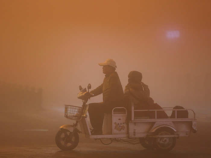 Two people ride during heavy smog in Lianyungang, Jiangsu province.