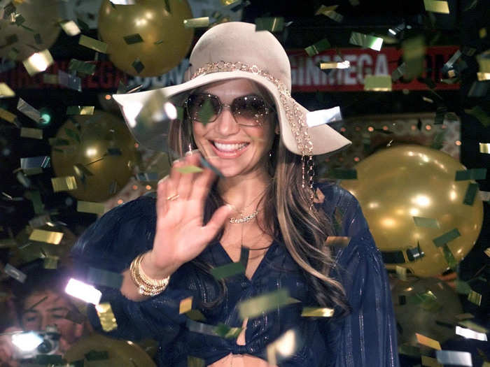 Nothing screams JLo (pictured at an album signing in 2001) more than this outfit: the crop top, lace-up gold pants, body chain, gold jewelry, floppy hat, and oversized sunglasses.