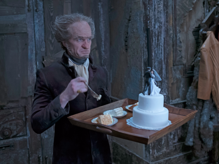 The man with hooks for hands offers Olaf a few choices of cake flavors. One