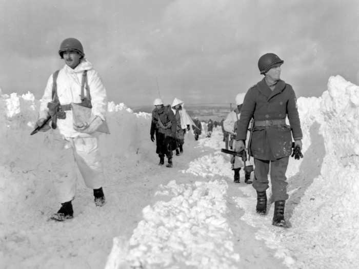 American infantrymen of an armored division march on a snow-covered road southeast of Born, Belgium, on January 22, 1945.