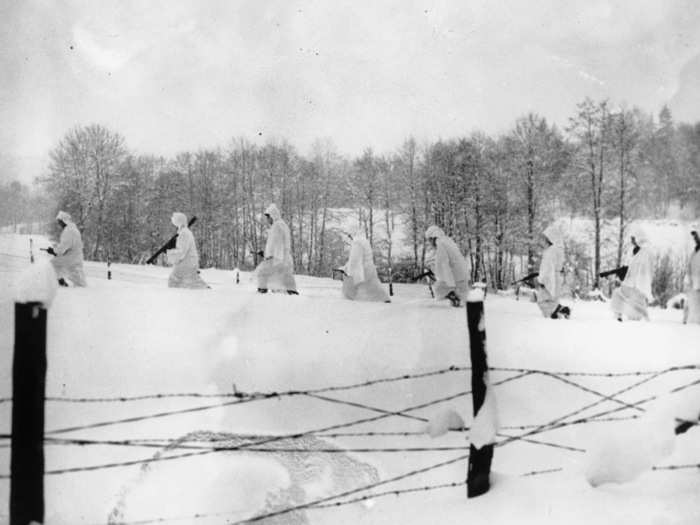 Members of a field artillery unit of the 30th US Division are seen moving along the front line in the Ardennes region near Stavelot, Belgium, during the Battle of the Bulge, on January 14, 1945.