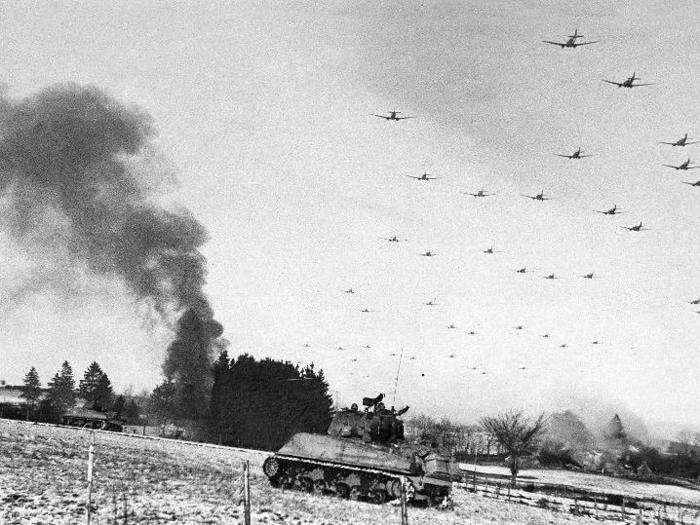 Low flying C-47 transport planes roar overhead as they carry supplies to the besieged American Forces battling the Germans at Bastogne, during the enemy breakthrough on January 6, 1945, in Belgium.