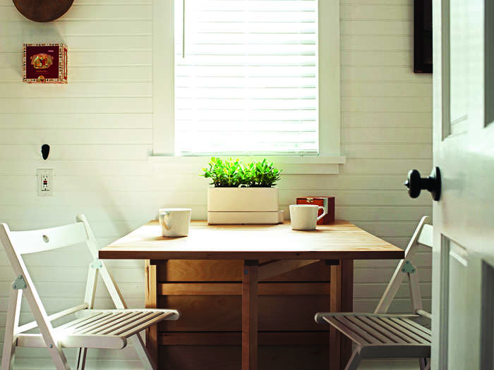 To save space in the kitchen, the table can fold up, and chairs can hang on the wall.