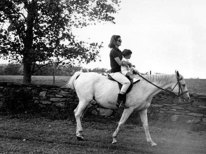 Here, first lady Jacqueline Kennedy rides with her son on the Hammersmith Farm property in 1962.