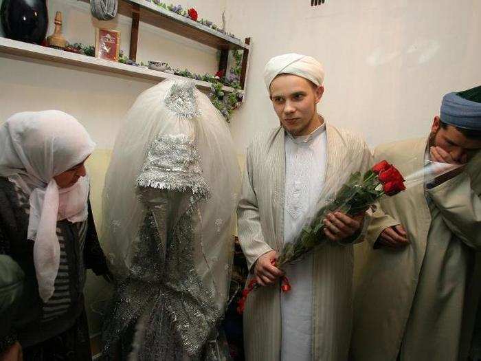 A traditional bride in Tajikistan wears a simple white dress over a pair of trousers. Over the course of the ceremony, which can last days, she may change into corresponding gowns.