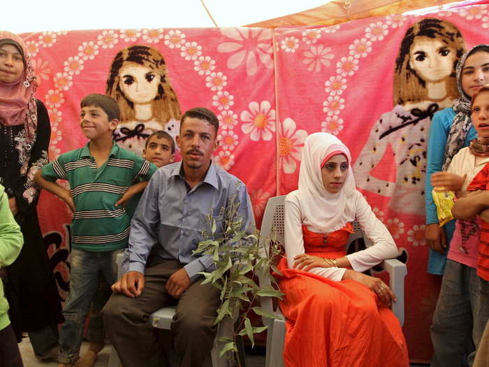 The Syrian bride wears a long-sleeved gown and gold jewelry, given by her family. The dresses come in a rainbow of colors, though most brides prefer white.