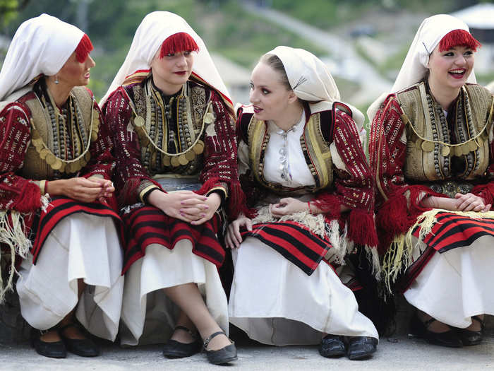 In a traditional wedding in Macedonia, the bride wears an intricately embroidered smock in red, white, and gold.