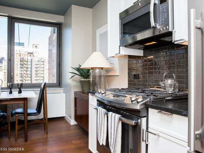 ... and a kitchen with stainless steel appliances and custom cabinetry.