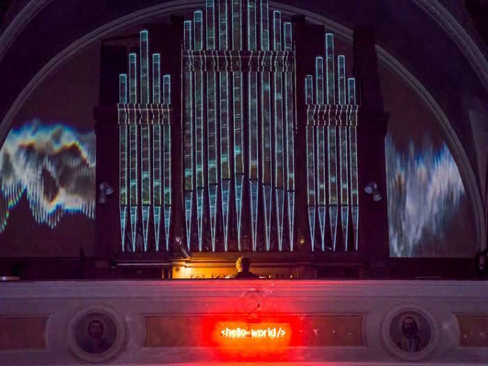 Hack Temple is home to one of the oldest organs in the US. A neon sign that includes a line of HTML coding hangs just below it.