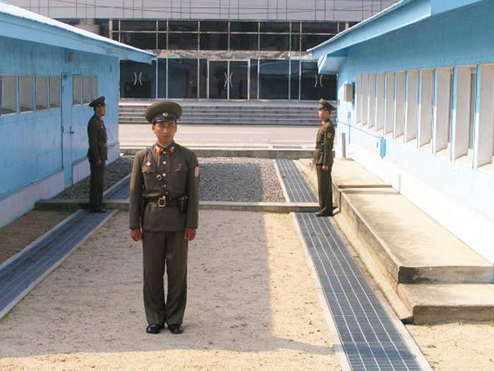 ... as 3 North Korean soldiers stand opposite. Rumor is that they face each other in case one decides to run into the South. The one facing the camera likely keeps anyone else from heading south.