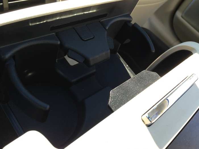 Two cupholders are neatly stowed in a retractable armrest compartment.