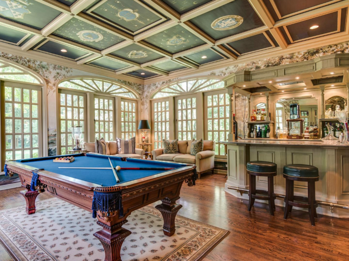 On one side is an attached billiards room with a pool table and bar.