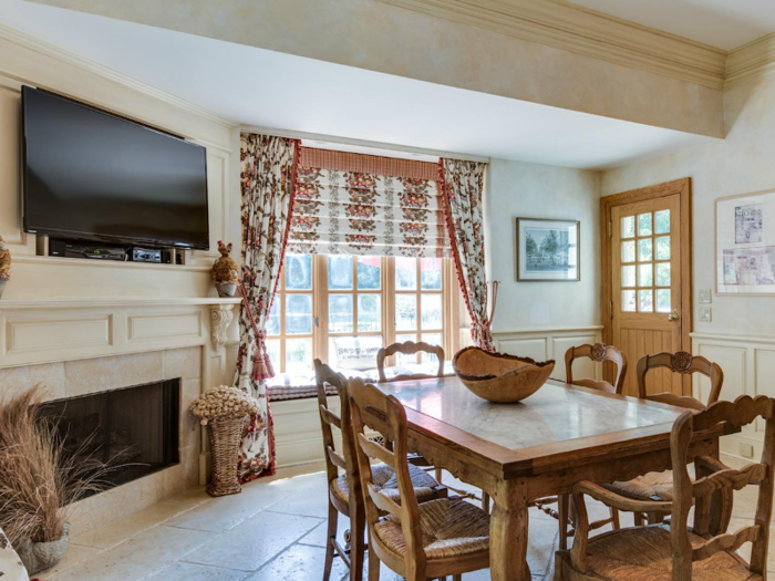 Attached to the main kitchen is a small breakfast area with a gas fireplace and a bay window seat. A door leads out to the back of the property.