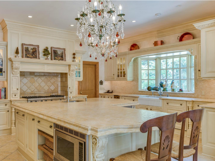 The main kitchen was built for entertaining. In the center is a large, marble-topped island with a built-in prep sink on one side and seating on the other. The kitchen has two dishwashers, a double oven, and a wine cooler.