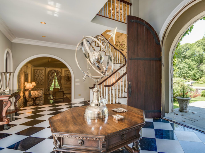 8,700 square feet in total, this mansion has an impressive entrance. Large, arched mahogany doors open into a hallway with a checkered marble floor.