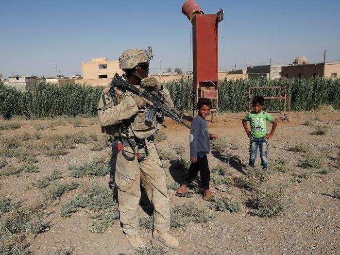 There are also about 1,000 US troops in Syria advising and backing up SDF forces. Below is a US soldier standing next to Syrian children on a road outside of Raqqa.