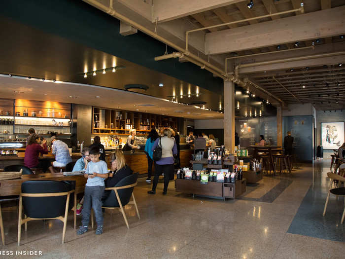 When you first walk in, a few things stand out. The place is huge, with customers gathered around long communal tables and a low, wood-clad bar where you can watch baristas work.