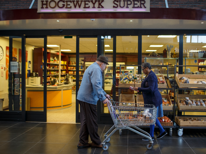 Hogeweyk caregivers and house attendants use an in-house currency to help their residents buy groceries at a fully-functional supermarket.