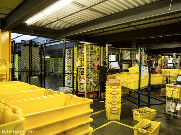 After speaking with Olsen, we left the warehouse to check on the line. We headed out to the exit, past employees filling a number of yellow bins with Amazon purchases.