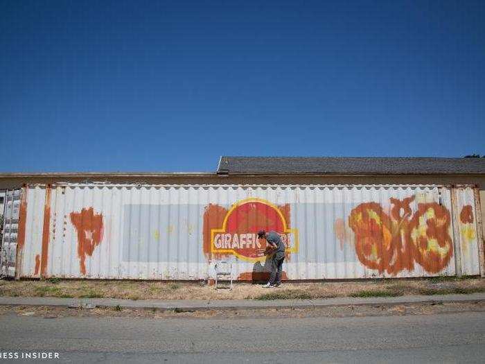 Nearby, I spotted a graffiti artist working on a shipping container.