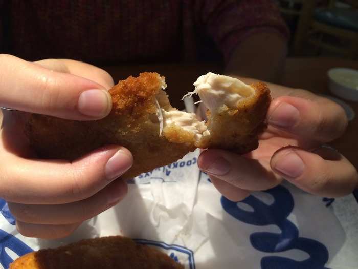 The chicken tenders come out steaming hot. The white-meat chicken is covered in a crispy fried coating.