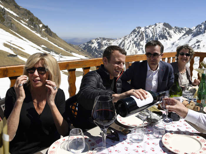 At the top, the couple looked relaxed as they shared a bottle of wine with colleagues.