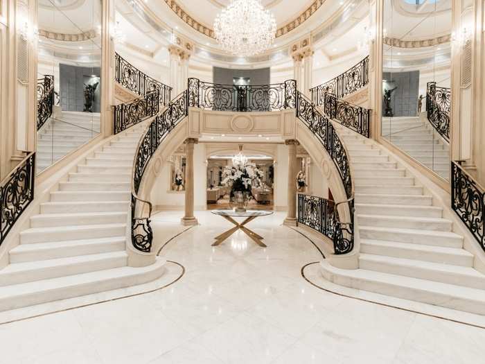 Inside, two marble staircases lead to the second floor of the two-story foyer.