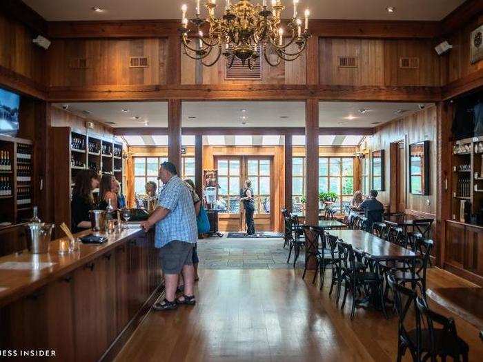 The interior is spacious, bright, and rich with dark woods. A chandelier overhangs the tasting counter.