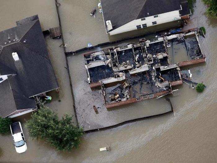 The flooding engulfed downed wires and caused fires in some buildings. A burned home in Spring, Texas is shown here, surrounded by water.