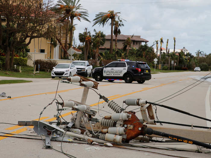 On the oceanfront A1A state road in Boca Raton, a police cruiser secured a fallen power pole.