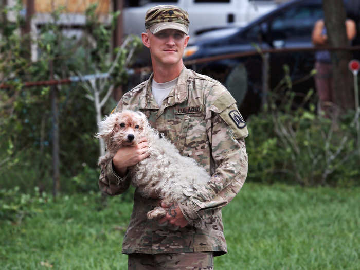 Elsewhere, residents of flooded suburbs had to flee. In Orlando, Army National Guard Spc. Thomas Hogan rescued a dog from a submerged neighborhood.