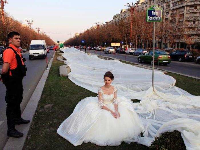 A Romanian woman wore a wedding dress with the longest train in the world during a Guinness World Record attempt in Bucharest.