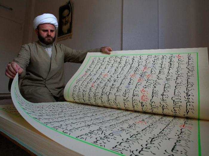 Hassan al-Zayyat shows off Quranic verses that he had copied by hand on 39- by 28-inch paper, aspiring to enter the Guinness Book of World Records for the largest handwritten Quran, in 2010.