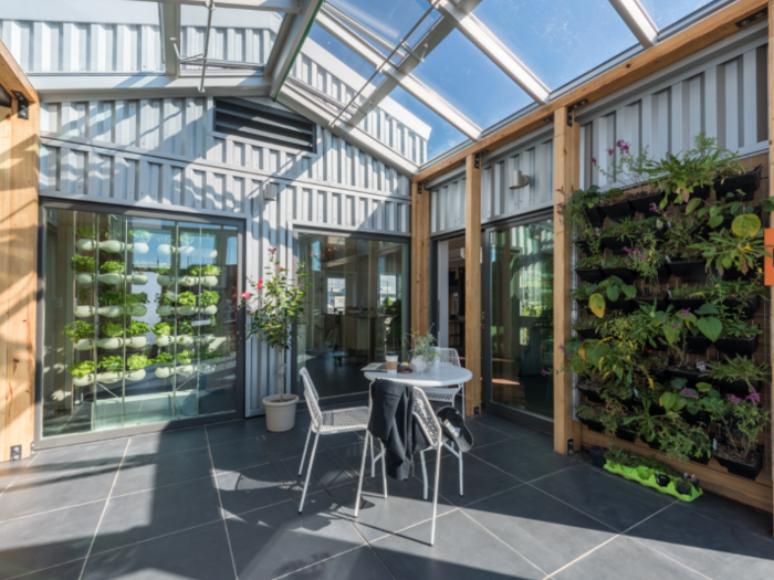 In addition to growing crops, the enclosed greenhouse has a system that can capture, store, and distribute warm air throughout the home during colder months.