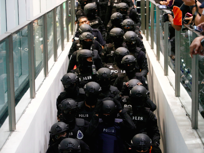 Here, police pack in to an escalator.