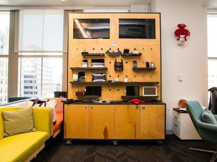 Off the kitchen is an open-concept workspace just like on the floor above. This one has a charging wall of fancy tech and Batman memorabilia.