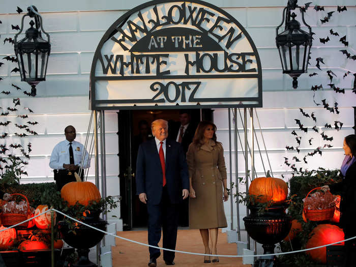 The Trumps greeted the wave of zombies, robots, and other costumed children for the Halloween event.