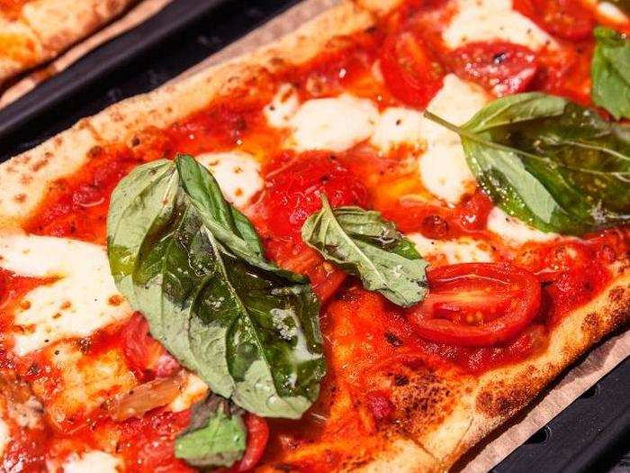 The OG is a simple spin on the Margherita pizza: basil, tomatoes, and mozzarella, with a drizzle of olive oil.