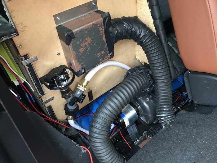 The plumbing and venting are hidden behind the rear seats. If you look closely, you can see the blue water bladder. It