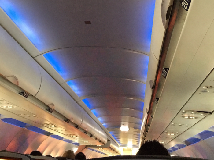 On board the plane, mood lighting bathed the cabin in a blue hue.