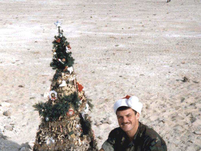 In this photo from 1990, Marine David Gurfein sits next to a Christmas tree in Saudi Arabia during Operation Desert Storm.