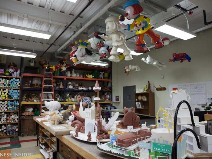 Models are then made scaled to size; you can see them sitting on the table here. Hanging above are balloon models from past parades.