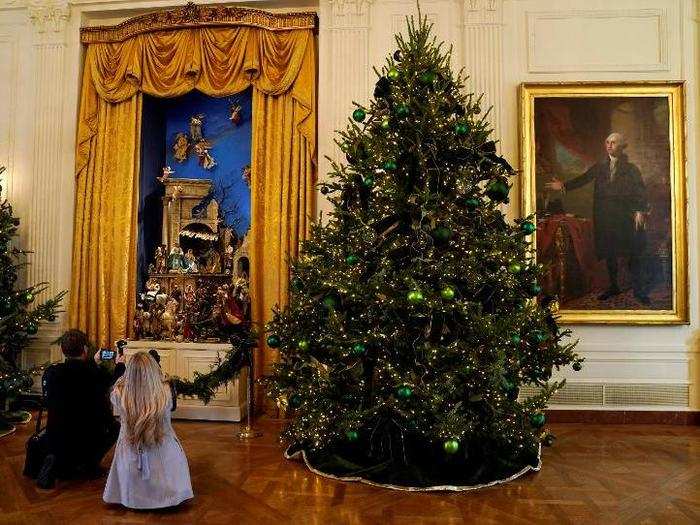 Photographers took pictures of the incredible White House nativity set, called a crèche, framed by more Christmas trees next to former President George Washington